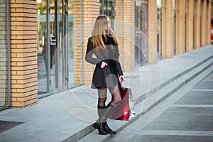 Sale, consumerism and people concept - happy young beautiful women holding shopping bags, walking away from shop.