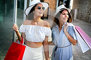 Sale, consumerism, shopping and people concept. Happy young women with shopping bag