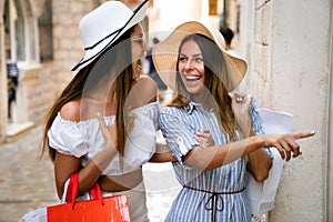 Sale, consumerism, shopping and people concept. Happy young women with shopping bag