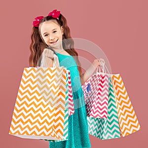 Sale. Cute little girl with many shopping bags. Portrait of a kid on shopping.