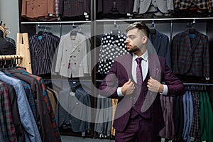 Sale, fashion, retail, business style and people concept - seriously hipster man with beard at clothing store