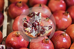 Sale of fresh of ripe juicy pomegranates, farmer`s bazaar, open showcases of market. Vegetarian concept, diet, detox