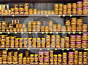 Sale of honey in a specialized store: honey is in jars of different shapes with the addition of nuts and dried films