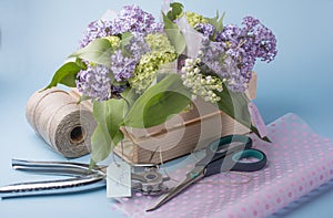 Sale of lilac bouquets in a wooden box.