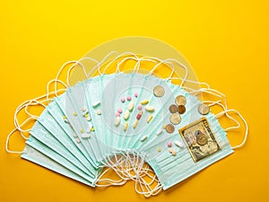 Sale of medical masks. Protective medical mask and different types of pills next to money on yellow background