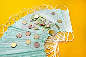 Sale of medical masks. Protective medical mask and different types of pills next to money on yellow background.The
