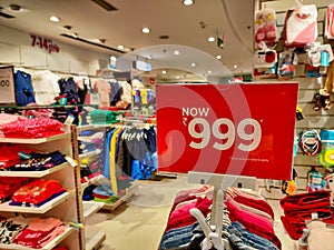 Sale price of Rs 999 for specific clothes on the top of hangers photo