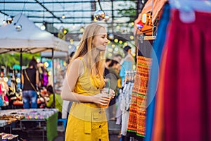 Sale, retail, shopping and clothing concept - Woman chooses clothes in the Asian market