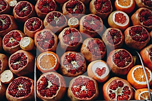 Sale of ripe juicy pomegranates, oranges in a street market. Open showcase of farmer`s market