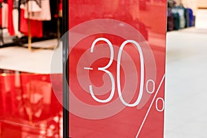 Sale. Shop window with 30 percent discount. Winter sale. Window shop with dressed mannequin, text Sale and 30 percent