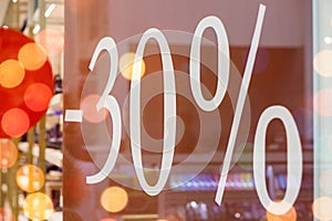 Sale. Shop window with 30 percent discount. Winter sale. Window shop with dressed mannequin, text Sale and 30 percent