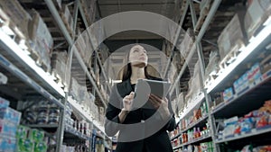 Sale, shopping, consumerism and people concept - close up of young woman with tablet pc computer in market, supevisor in