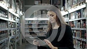 Sale, shopping, consumerism and people concept - close up of young woman with tablet pc computer in market, supevisor in