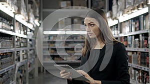 Sale, shopping, consumerism and people concept - close up of young woman with tablet pc computer in market, supevisor in