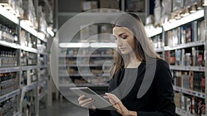 Sale, shopping, consumerism and people concept - close up of young woman with tablet pc computer in market, supevisor in