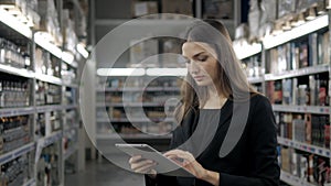 Sale, shopping, consumerism and people concept - close up of young woman with tablet pc computer in market, supevisor in