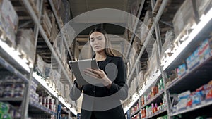 Sale, shopping, consumerism and people concept - close up of young woman with tablet pc computer in market, supevisor in