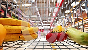 Sale, shopping, consumerism and people concept - man with shopping cart at grocery store or supermarket