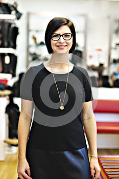 A sale, shopping and people concept happy young woman or shop assistant at store