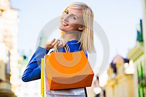 Sale, shopping, tourism and happy people concept - beautiful woman with shopping bags in the ctiy