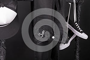 Sale sign. Black and white snaekers, cap pant, jeans hanging on clothes rack background. friday. Close up.