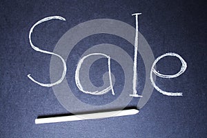 Sale sign on blue chalk board with chalk
