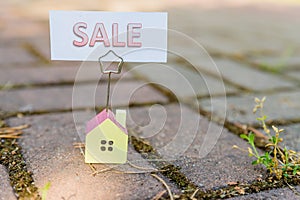 Sale sign with small model house - real estate buying concept.Copy space. home and life concept. Small model home with