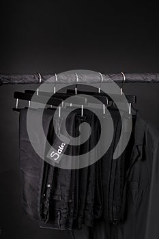 Sale sign. A lot of black pants jeans and jacket hanging on clothes rack. background. friday. Copy space.