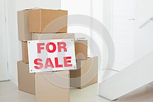 For sale sign with many cardboard boxes