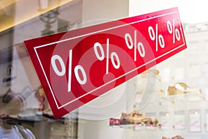 Sale sign in a store window with percent signs