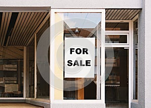 For sale sign in store window - shop vacancy due to business clo