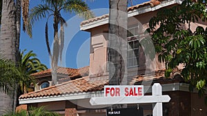 For Sale sign on suburban home