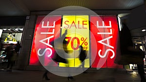 Sale signs in shop window, big reductions