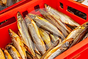 Sale of smoked Kamchatka fish. Far Eastern seafood, natural smoked fish - smelt salmon at the city Christmas market