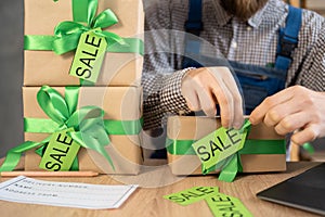 Sale for St. Patrick& x27;s Day. Entrepreneur small business owner packing boxes with green ribbon for delivery and