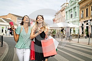 Sale and tourism, happy people concept. Beautiful women friends with shopping bags in the ctiy