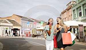 Sale and tourism, happy people concept. Beautiful women friends with shopping bags in the ctiy