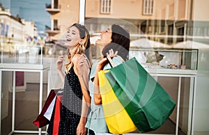 Sale and tourism, happy people concept. Beautiful women friends with shopping bags in the ctiy