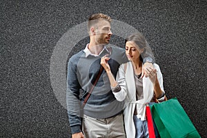 Sale, travel love consumerism and people concept. Happy couple with shopping bags in the city