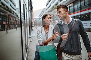 Sale, travel love consumerism and people concept. Happy couple with shopping bags in the city