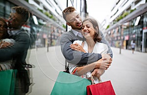 Sale, travel love consumerism and people concept. Happy couple with shopping bags in the city