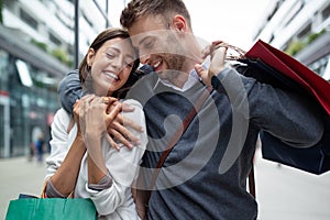 Sale, travel love consumerism and people concept. Happy couple with shopping bags in the city