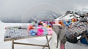 Sale of warm woolen things on the top of one of the mountains. Handmade knitted items: socks, gloves, hats. Travel to the Caucasus