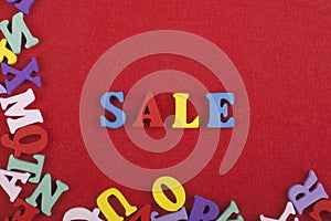 Sale word on red background composed from colorful abc alphabet block wooden letters, copy space for ad text. Learning english