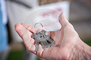 Saleman holding keys of new house, house for sale concept photo