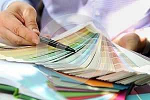 Sales agent choosing color samples for design project.