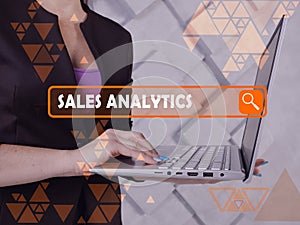 SALES ANALYTICS text in search bar. Broker looking for something at laptop. SALES ANALYTICS concept