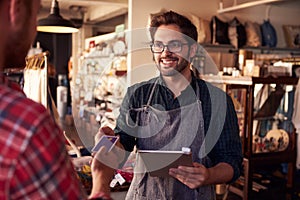 Sales Assistant With Credit Card Reader On Digital Tablet