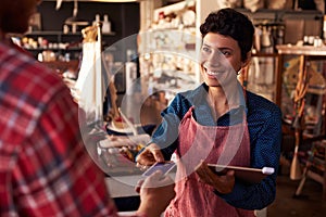 Sales Assistant With Credit Card Reader On Digital Tablet