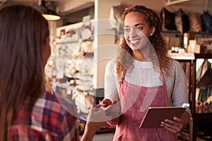 Sales Assistant With Credit Card Reader On Digital Tablet